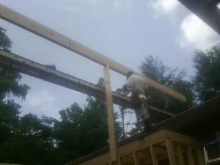 Carpenter setting a ridge beam over a new addition frame — Ice Dam Removal by Roofing Brothers in Eagle River