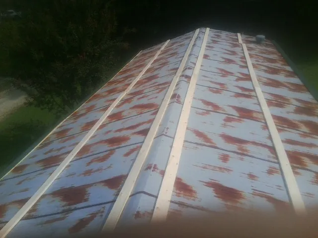Rusted metal roof panels with new wood purlins before replacement — Storm Damage Roof Repair in Eagle River by Roofing Brothers