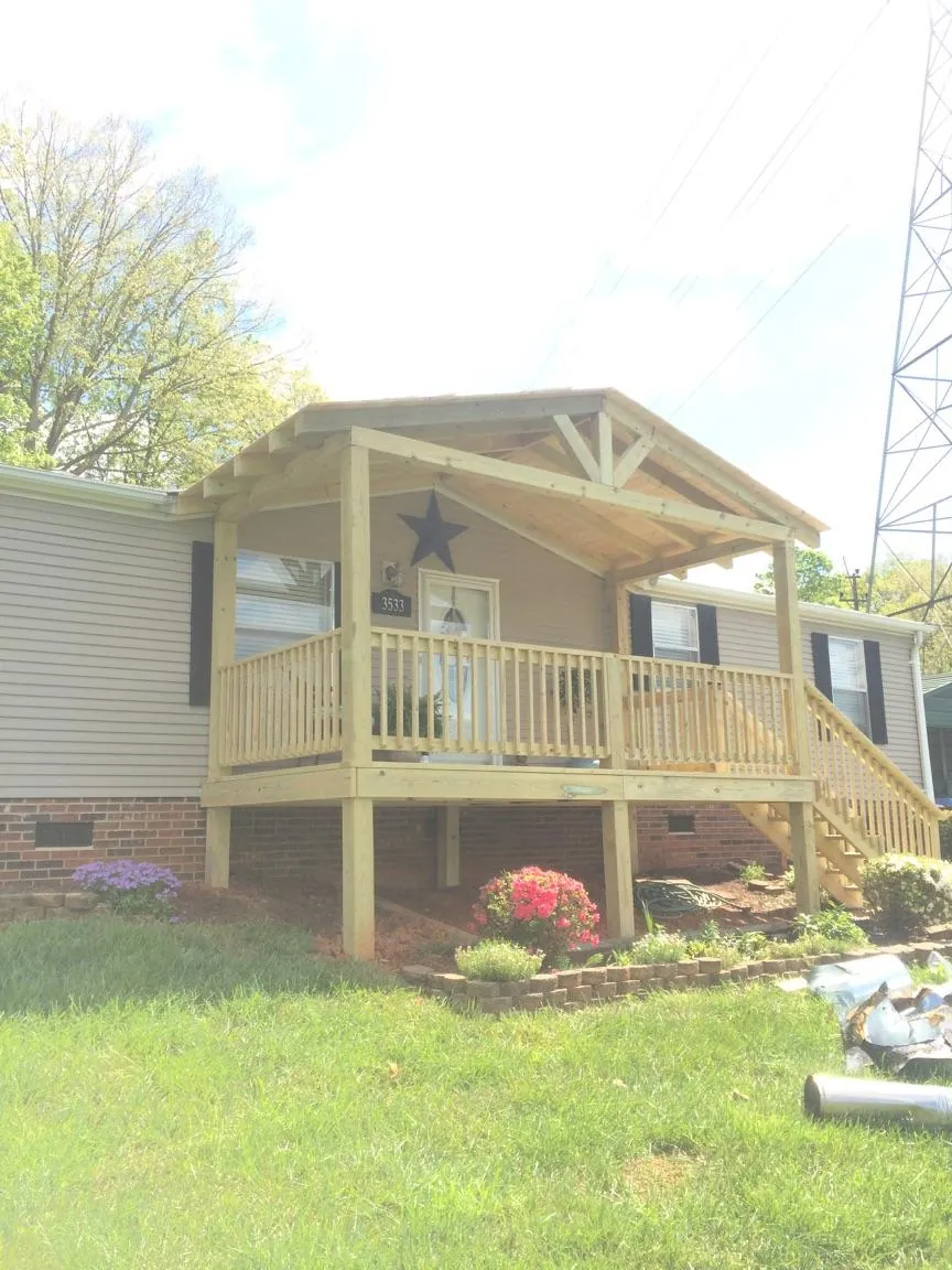 New gabled porch roof and deck railing added to a ranch home in Eagle River